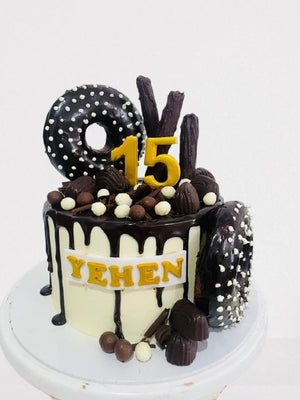 Birthday cake with chocolate decorations, number '15', and the name 'YEHEN' on a white background