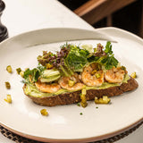 Sour Dough Toast with Grilled Marinated Prawns and Crushed Avocado by Hotel Cinnamon Grand